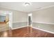 Empty dining room features hardwood floors, neutral walls with white trim, and a view into the kitchen and living room at 58 Penn Pl, Zionsville, IN 46077