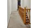 Long hallway features carpeted floors, neutral walls, and a wooden staircase railing at 58 Penn Pl, Zionsville, IN 46077
