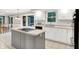 Bright kitchen featuring white cabinets, tile countertops, an island cooktop, and stainless appliances at 58 Penn Pl, Zionsville, IN 46077