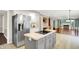 Open kitchen view with stainless steel fridge, island cooktop, and seamless access to the living area at 58 Penn Pl, Zionsville, IN 46077