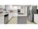 Modern kitchen boasting stainless steel appliances, an island cooktop, and ample cabinet space at 58 Penn Pl, Zionsville, IN 46077