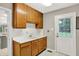 Laundry room features wooden cabinets, a sink, and access to the backyard at 58 Penn Pl, Zionsville, IN 46077