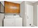 Laundry room features a side-by-side washer and dryer, upper cabinets, and access to the backyard at 58 Penn Pl, Zionsville, IN 46077