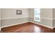 Living room features hardwood floors, neutral walls with white trim, and a bright window with blinds at 58 Penn Pl, Zionsville, IN 46077