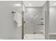 Shower featuring a frameless glass door and marble-tile surround with built-in shelving at 58 Penn Pl, Zionsville, IN 46077