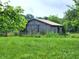 Rustic barn in a verdant field, surrounded by trees at 6003 S 125 W, Trafalgar, IN 46181