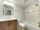Modern bathroom with dark wood vanity, gold fixtures, and shower-tub combo with white tiled walls at 602 S Sherman Dr, Indianapolis, IN 46203