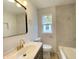 Bright bathroom featuring neutral tile, a single sink vanity, and tub-shower combination with gold fixtures at 602 S Sherman Dr, Indianapolis, IN 46203