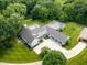 An aerial view of a luxury estate boasting a modern home, a sprawling driveway, and a serene pond nearby at 6115 Stonegate Run, Zionsville, IN 46077