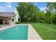 Expansive backyard featuring a pool, lush green lawn, mature trees, and a modern home design at 6115 Stonegate Run, Zionsville, IN 46077