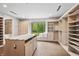Walk-in closet with custom shelving, storage island, hardwood floors and a large window overlooking the yard at 6115 Stonegate Run, Zionsville, IN 46077