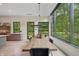 Dining area has a large wood table with an elegant light fixture and large windows with a view to yard at 6115 Stonegate Run, Zionsville, IN 46077
