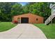 Long concrete driveway leading to a brown detached garage with open doors and stairs to a light blue structure at 6115 Stonegate Run, Zionsville, IN 46077