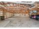 Spacious detached garage with exposed wood beams, hanging lights, and a golf cart on the concrete floor at 6115 Stonegate Run, Zionsville, IN 46077
