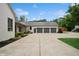 Side view showcasing a three-car garage with neutral colors, adjacent to a house with impeccable landscaping at 6115 Stonegate Run, Zionsville, IN 46077