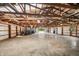 Expansive detached garage showcasing exposed wood beams, hanging lights, and ample storage space at 6115 Stonegate Run, Zionsville, IN 46077