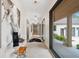 Inviting hallway illuminated by stylish light fixtures, complemented by modern decor and access to outdoor views at 6115 Stonegate Run, Zionsville, IN 46077