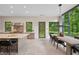 Open kitchen and dining area with sleek cabinetry, a large island, and oversized windows to backyard at 6115 Stonegate Run, Zionsville, IN 46077