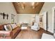 Warm living room featuring a leather sofa, hardwood floors, wood-beam ceiling and recessed lighting at 6115 Stonegate Run, Zionsville, IN 46077
