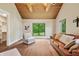 Comfortable living room featuring a leather sofa, wood-beam ceiling and hardwood floors at 6115 Stonegate Run, Zionsville, IN 46077