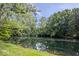 Peaceful pond reflecting the surrounding trees and sky on a clear day at 6115 Stonegate Run, Zionsville, IN 46077