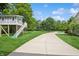 Exterior of a multi-structure home with a detached, elevated playhouse and expansive lawn with concrete driveway at 6115 Stonegate Run, Zionsville, IN 46077