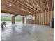 Spacious two-car garage interior featuring an unfinished ceiling, concrete floor and open garage door at 6295 State Road 142 Rd, Martinsville, IN 46151