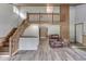 Open-concept living room with a wooden staircase, hardwood flooring, and a loft area above at 6295 State Road 142 Rd, Martinsville, IN 46151