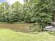 Picturesque view of the pond with a dock, surrounded by lush greenery at 6295 State Road 142 Rd, Martinsville, IN 46151