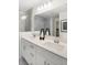 A modern bathroom with double vanity, quartz countertops, and a glass-enclosed shower with marble-style tiles at 6580 Halsey St, Zionsville, IN 46077