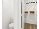 A modern bathroom with white door and a view to walk-in closet with wire rack at 6580 Halsey St, Zionsville, IN 46077