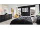 Well-lit primary bedroom boasts dark accent wall, plush carpet, modern furniture, and en-suite bathroom access at 6580 Halsey St, Zionsville, IN 46077