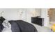 Modern bedroom with neutral color palette, sleek black dresser, and view to a marble-tiled bathroom at 6580 Halsey St, Zionsville, IN 46077