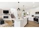 Open kitchen with stainless appliances, gas range, white cabinets, an island, and hardwood floors throughout at 6580 Halsey St, Zionsville, IN 46077