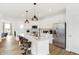Bright kitchen boasts white cabinets, stainless steel appliances, quartz counters, and an island with bar seating at 6580 Halsey St, Zionsville, IN 46077