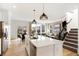 Contemporary kitchen featuring stainless appliances, a large island, and views of the adjacent dining and living spaces at 6580 Halsey St, Zionsville, IN 46077