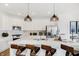Modern kitchen featuring white cabinets, stainless steel appliances, quartz counters, and stylish pendant lighting at 6580 Halsey St, Zionsville, IN 46077