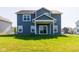 A spacious backyard features a well-maintained lawn with a covered patio sliding door and traditional blue siding at 6610 Aberdeen Dr, McCordsville, IN 46055