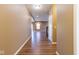 Hallway with hardwood flooring leading to a brightly lit living area and stairwell at 6610 Aberdeen Dr, McCordsville, IN 46055