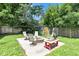 Backyard patio area with chairs, fire pit, grill and lush grass at 6741 Evanston Ave, Indianapolis, IN 46220