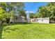 Wide backyard featuring lawn, mature trees, exterior house, garage and other outbuildings at 6741 Evanston Ave, Indianapolis, IN 46220