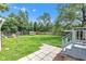 Spacious backyard with lush green lawn, patio area, fire pit, dog house and mature trees at 6741 Evanston Ave, Indianapolis, IN 46220
