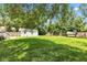 Lush, green backyard featuring various outbuildings, a patio area, and mature shade trees at 6741 Evanston Ave, Indianapolis, IN 46220