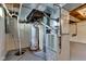 Basement featuring water heater and furnace with exposed beams and walls at 6741 Evanston Ave, Indianapolis, IN 46220