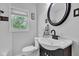 A well-lit bathroom featuring a window, a dark vanity, and a toilet at 6741 Evanston Ave, Indianapolis, IN 46220