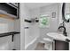 A modern bathroom has a shower/tub combination and dark wood shelving next to a white vanity at 6741 Evanston Ave, Indianapolis, IN 46220