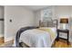 A bedroom with natural light features a comfortable bed and a stylish side table with a lamp at 6741 Evanston Ave, Indianapolis, IN 46220