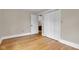 A sunlit bedroom with hardwood floors leads to an open door and a spacious closet at 6741 Evanston Ave, Indianapolis, IN 46220