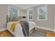 A cozy bedroom features two large windows and a comfortable bed with a soft throw blanket at 6741 Evanston Ave, Indianapolis, IN 46220