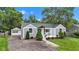 Charming single-story home with manicured lawn, front porch, mature trees, and one-car garage at 6741 Evanston Ave, Indianapolis, IN 46220
